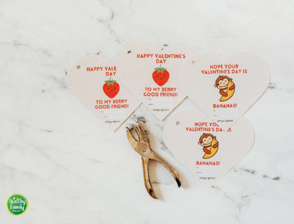 Four Crispy Green heartfelt messages, two featuring a strawberry and two featuring a monkey with a banana. A hole puncher is set to the side.